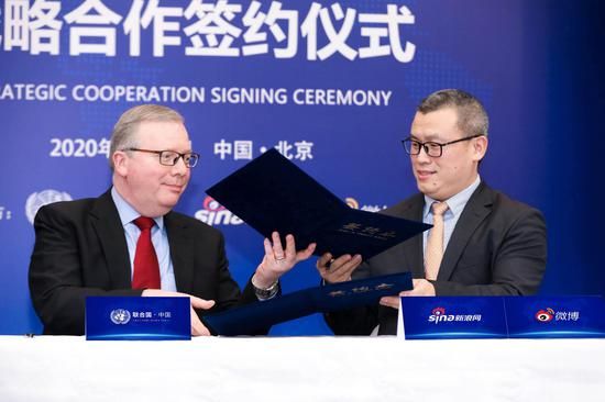 20日，联合国驻华机构与新浪、微博战略合作签约仪式上，新浪高级副总裁邓庆旭与联合国驻华协调员罗世礼交换协议文本。